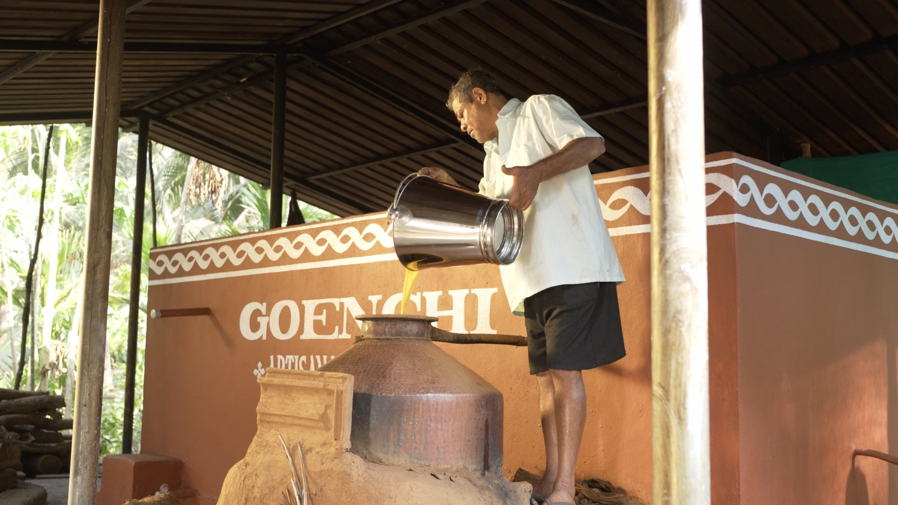 Traditional fermented cashew pouring - Goenchi Feni artisanal production